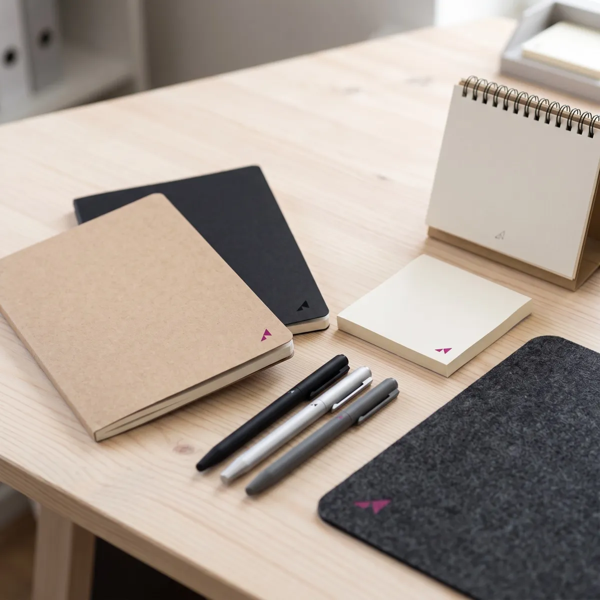 Libretas, bolígrafos, notas adhesivas y alfombrilla personalizadas sobre una mesa
