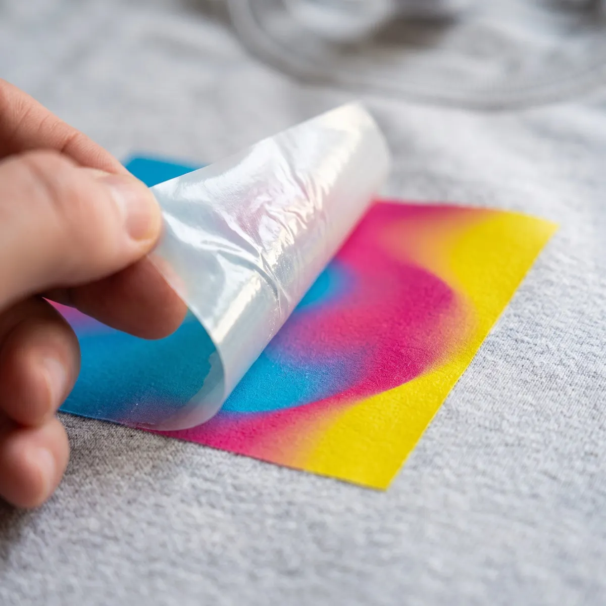 Transfer a todo color despegándose de una sudadera gris