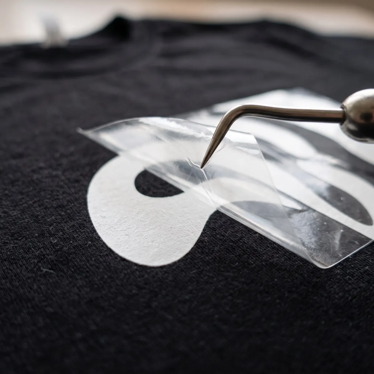 Vinilo textil blanco recién aplicado sobre una camiseta negra